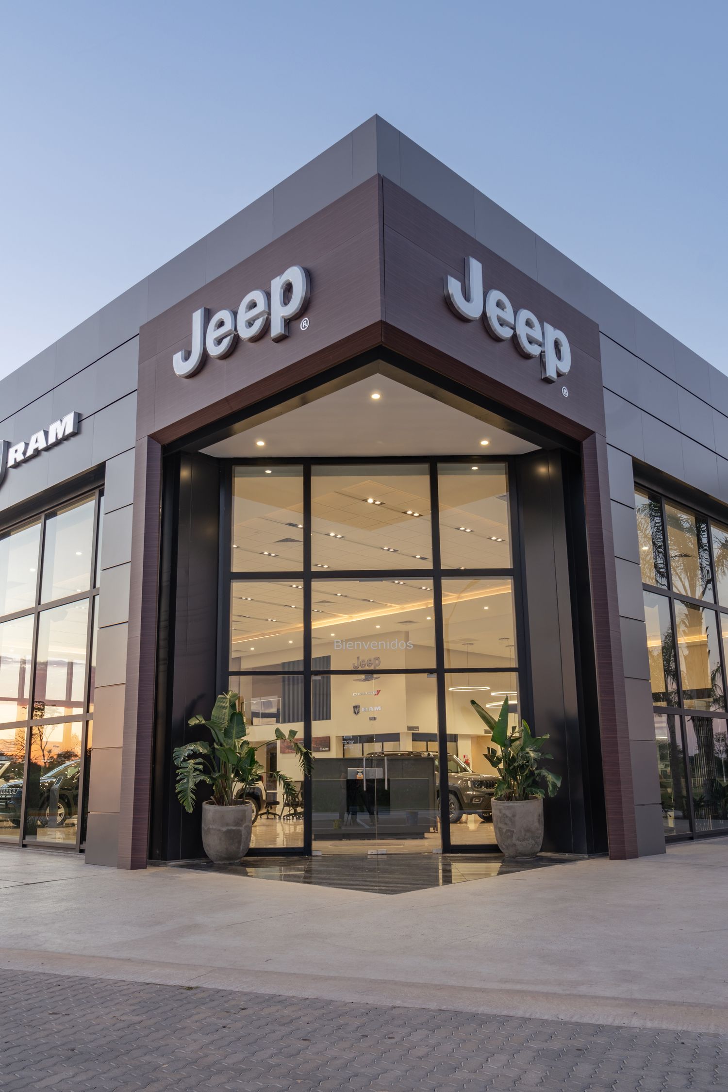 Concesionaria Jeep en Resistencia: esquina de acceso vidriada bajo el cartel, al atardecer